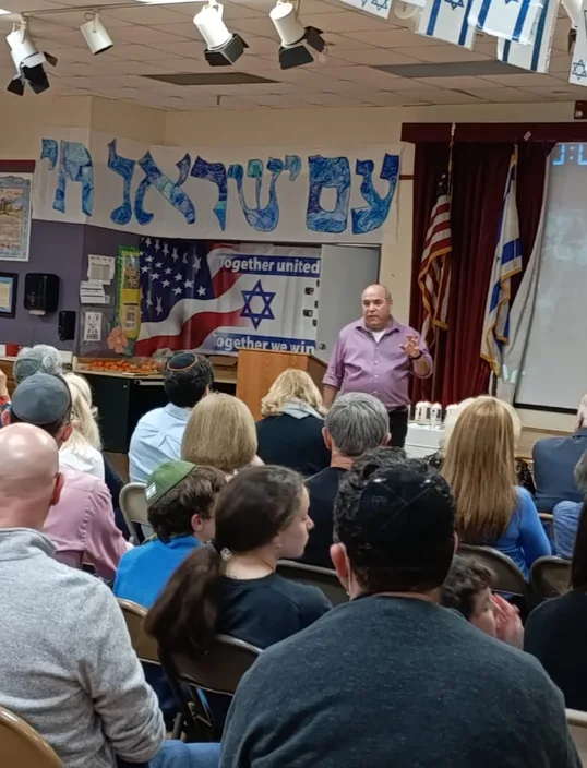 קהל בהרצאה באולם של בית ספר יהודי